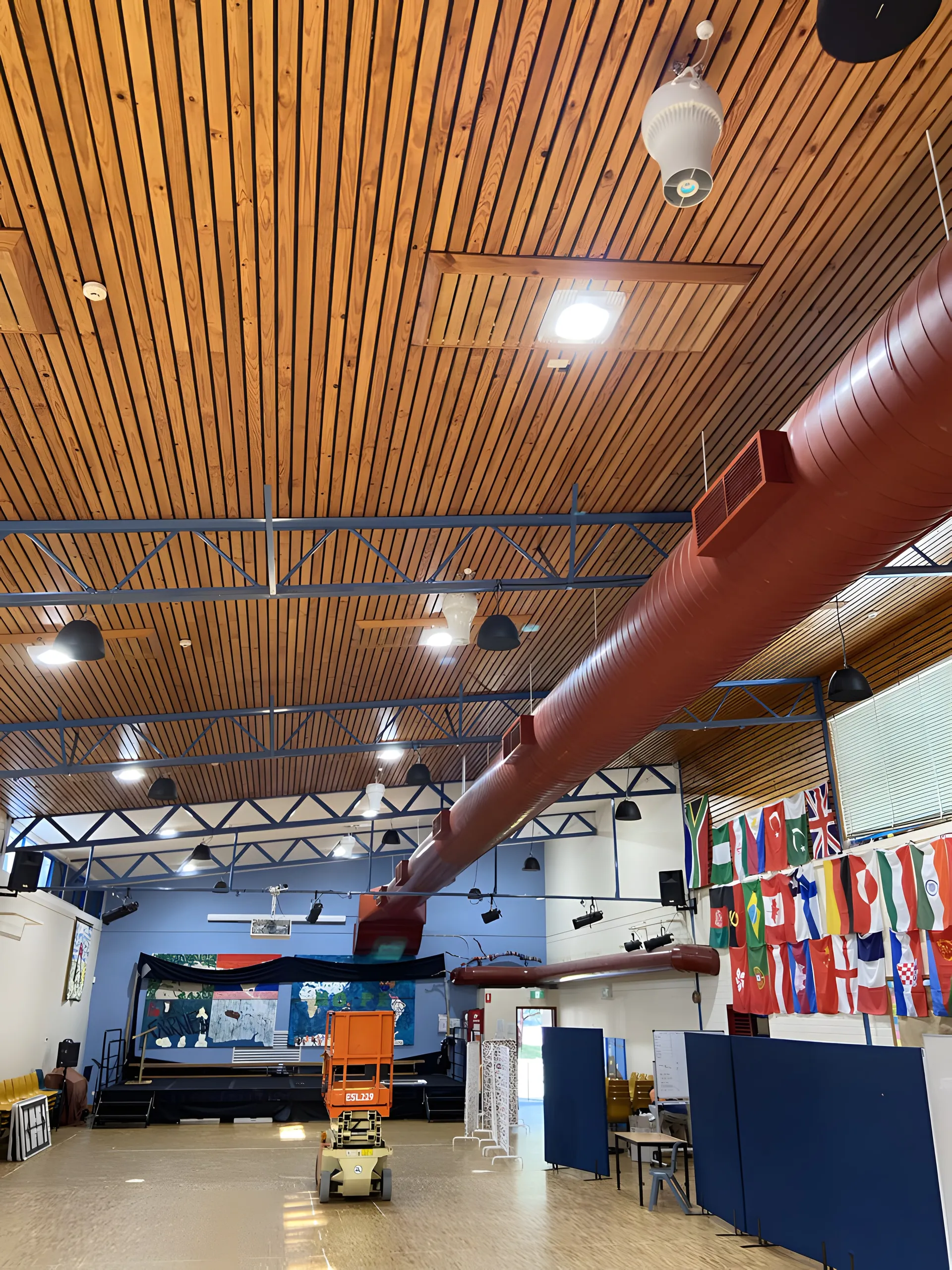 Exposed supply ductwork in a school hall